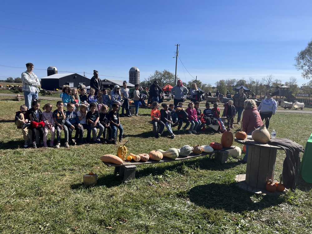 A school group gathered around the gourd display during a field trip at Crawford Farms