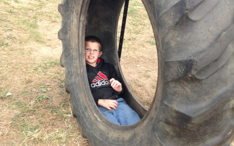 Child playing inside a giant tractor tire at Crawford Farms